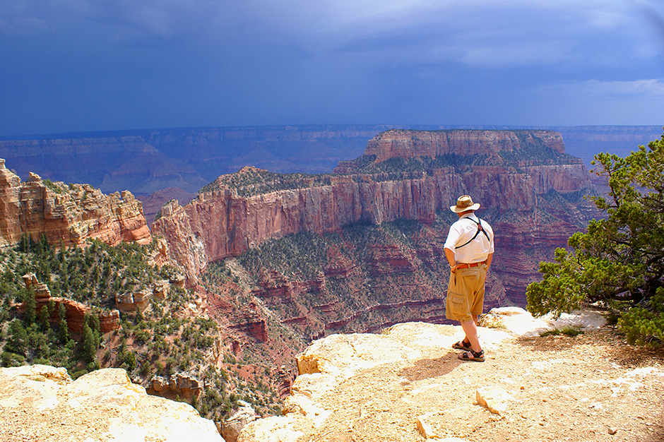 Marvel at the impressive views of the Grand Canyon with Amtrak Vacations. Man overlooking the Grand Canyon