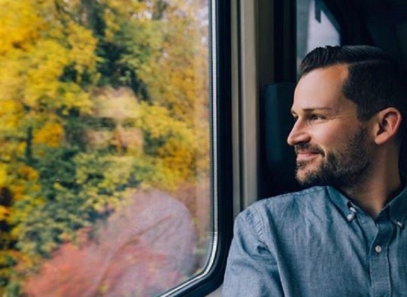 man looking out the window onboard an amtrak train