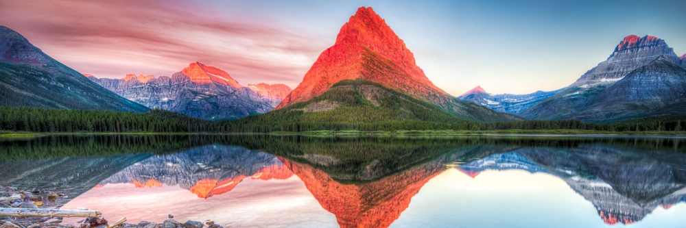 Stunning reflections on Swiftcurrent Lake in northern Montana at sunrise